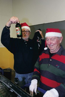 Bert Evertsson visar stolt upp den första flaskan av Ahle Julöl årgång 2011. Till höger ses Bernt Långö. 