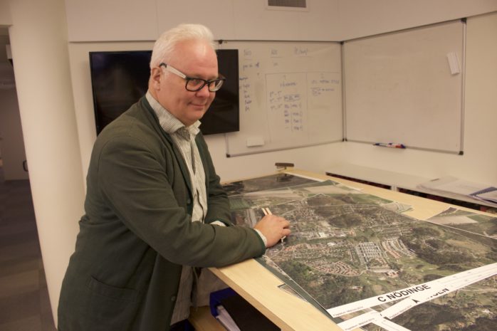 Stadsarkitekten Magnus Blombergsson kollar på kartorna över orterna i kommunen. Det kommer att byggas en hel del under nästa år. Foto: Kristoffer Stiller 
